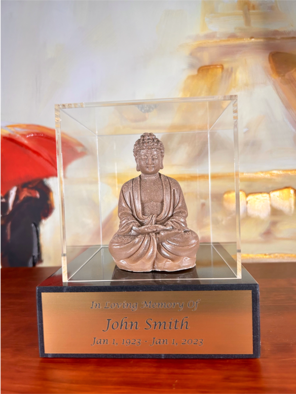 A photo of a Buddha Cremation Sculpture, featuring a serene Buddha figurine crafted from cremated remains, with an engraved base and an acrylic glass display case