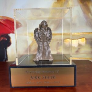 An Angel Sculpture with Cremation Ash, featuring a serene and delicate angel figure with wings, crafted from the ashes of a loved one. The sculpture is displayed on an engraved marble base and encased in acrylic glass for preservation.